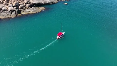 Top down view of a moving sailboat off the coast of an island. Stock Footage 266097519