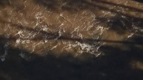 Top-down view of muddy river water flowing rapidly 動画素材 336360708