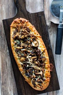 Top down view of a mushroom beef flatbread pizza ready for slicing. Foto stock