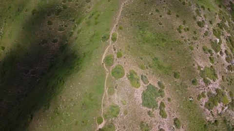 Top down view of narrow dirt pathway winding on green hillside in Kazakhstan 스톡 동영상 337120157