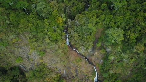 Top down view of a narrow multi-tiered waterfall in forested terrain of Costa Stock Footage 315436013
