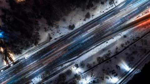Top down view to night road with passing cars with headlights on between the Stock Photos