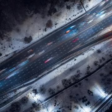 Top down view to night road with passing cars with headlights on between the Stock Photos