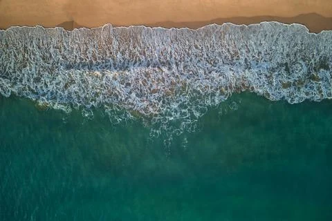 Top-down view of the ocean surf and the sand shore Stock Photos