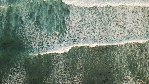 Top down view of ocean waves powerful surf crashing over shallow reef at dusk Stock Footage 344913847