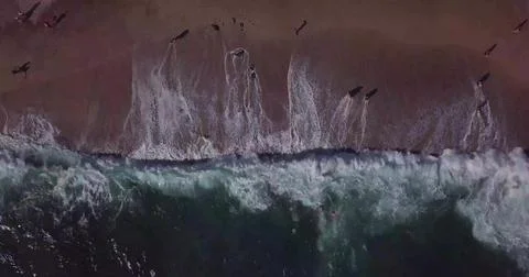 Top-Down View of Ocean Waves Rolling onto a Sandy Seashore Stock Photos