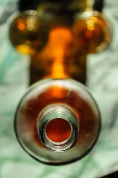 Top-down view of an open bottle with two glasses, filled with amber liquid. Stock Photos