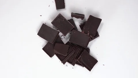 Top down view on open chocolate pieces. Dark chocolate revolves and spin on Stock Footage 124279331