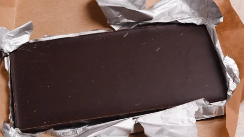 Top down view on open chocolate bar in package. Dessert on the table. Stock Footage 126117657