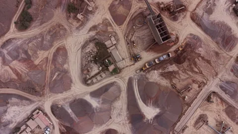 Top-down view of an open-pit mining site with red earth, winding dirt tracks Stock Footage 336742644