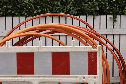 Top-down view of orange and grey cables behind a construction barrier. Stock Photos