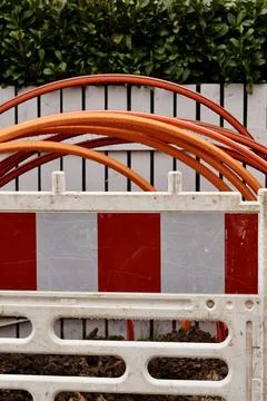 Top-down view of orange and grey cables behind a construction barrier. Stock Photos