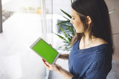 Top down view, over the head shot, woman holding a tablet with green screen Stock Photos