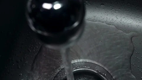 Top down view over running tap and water flowing down plug hole Stock Footage 104784061