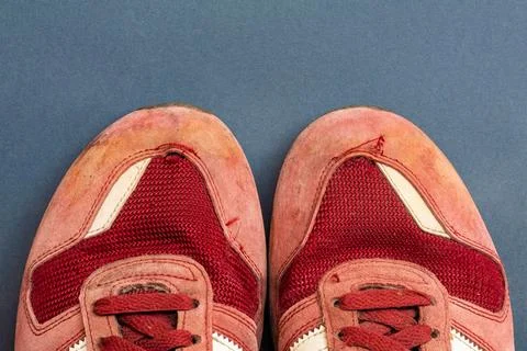 Top-down view of a pair of red sneakers placed on a graphite background Stock Photos