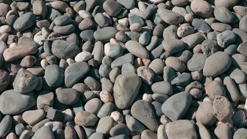 Top down view panning across smooth river stones Vidéo 348517274