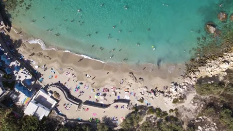 Top Down View Paradise Bay Beach with Swimmers Umbrellas and Turquoise Water Stock Footage 330924707