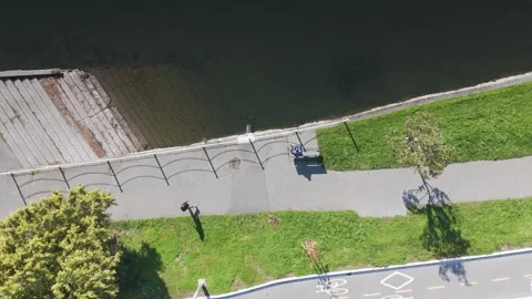 Top-down view of a paved path beside a body of water and bike lane markings Stock Footage 291613202