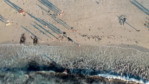 Top down view of people enjoying their time at the beach during sunset Stock Footage 170724558