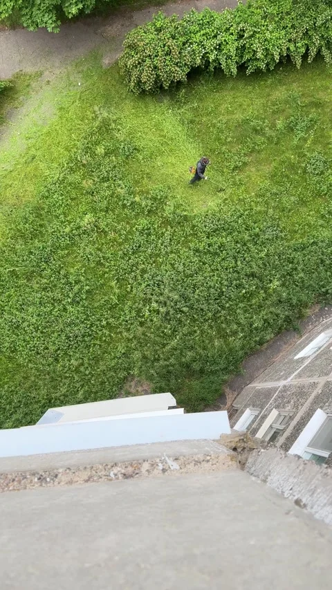 Top-down view of a person mowing grass with a trimmer Stock-Footage 337775053