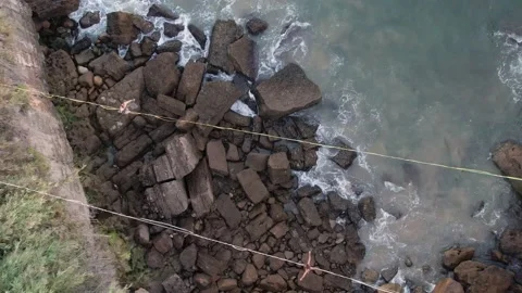 Top down view person walking on tightrope with waves crashing Stock Footage 209134915