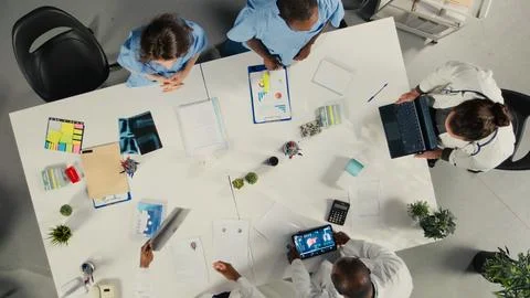 Top down view of physicians and medics gathered for briefing conference Stock Photos