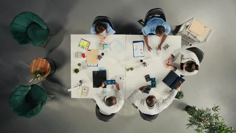 Top down view of physicians and medics gathered for briefing conference Stock Photos