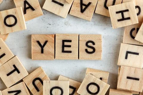 Top down view, pile of square wooden blocks with letters YES on white board 스톡 사진
