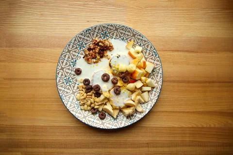 Top-down view of a plate with cottage cheese pancakes, yogurt, cereal loops.. Fotos de archivo
