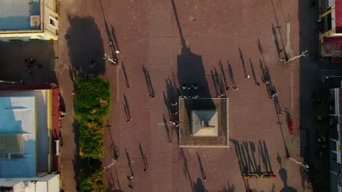 Top down view of plaza with central cross structure casting long shadows of 스톡 동영상 332824875