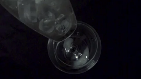 Top down view of pouring ice cubes into a wine glass in dark night background. Stock Footage 133545440