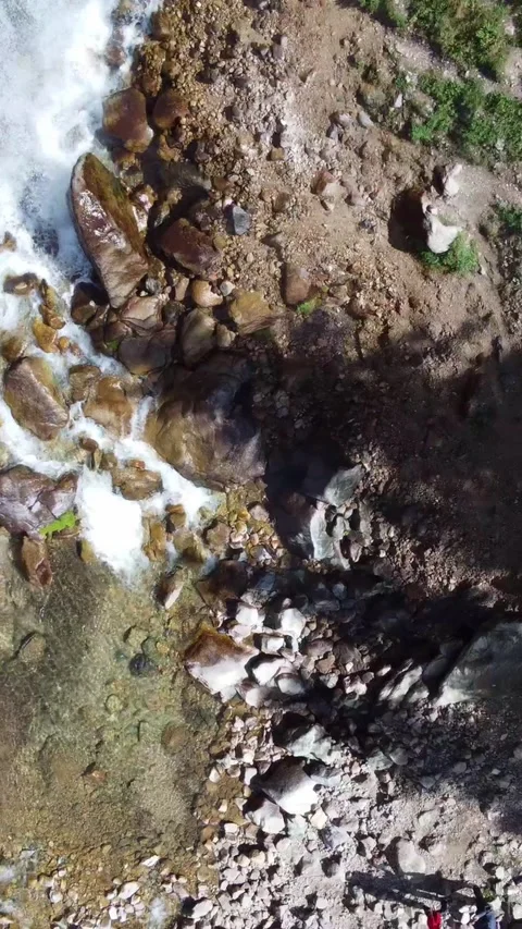 Top down view of powerful waterfall and hikers with dutch tilt effect Stock Footage 336691554