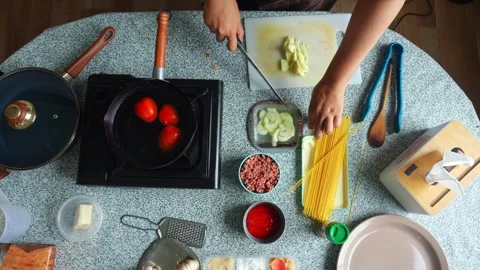 Top-down view of prepping sliced onions preparing ingredients to make spaghetti Stock Footage 345376735