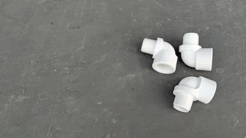 A top down view presents three white PVC plastic elbow pipe fittings with t.. Stock Photos