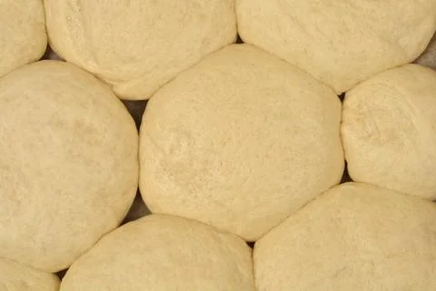 Top down view of proofed yeast dough buns expanding on baking paper Stock Photos