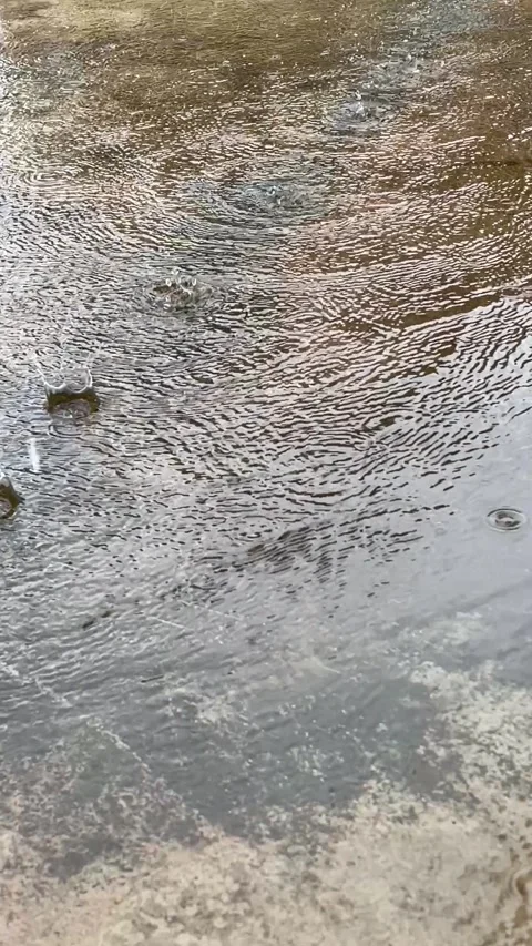 Top Down View Of Raindrops Falling On Thin Water Layer On Concrete Floor Stock Footage 321920612