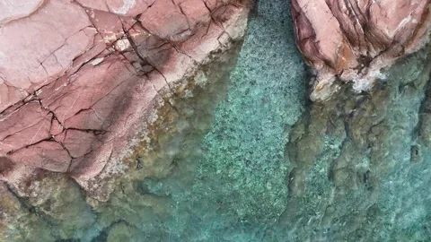 Top Down View of a Red Rocky Seabed Through Clear Turquoise Water Stock Footage 317204970