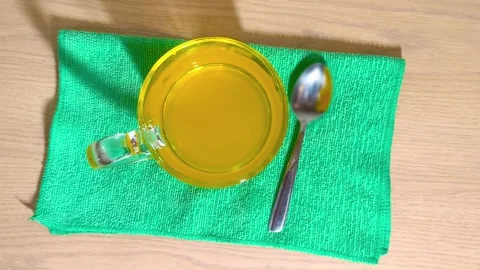 Top down view of refreshing orange citrus juice in clear glass cup with spo.. Video stock 318124631