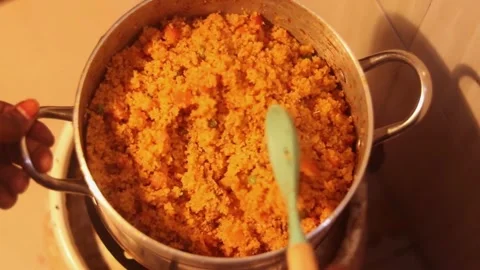 Top down view of rice and peas being stirred in a large pot on the stove in 스톡 동영상 330989119