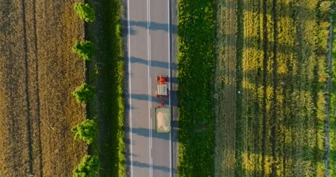 Top down view of the road and tractor driving along it at sunset. Stock Footage 210879209