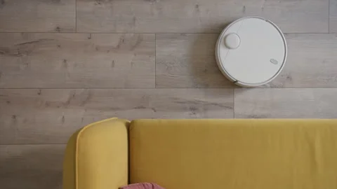 Top down view of robotic vacuum cleaner white color cleaning gray laminate next Video stock 243230524