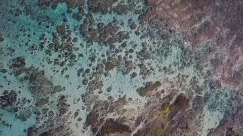 Top down view of the rocks under the turquoise water aerial footage Stock Footage 101991754