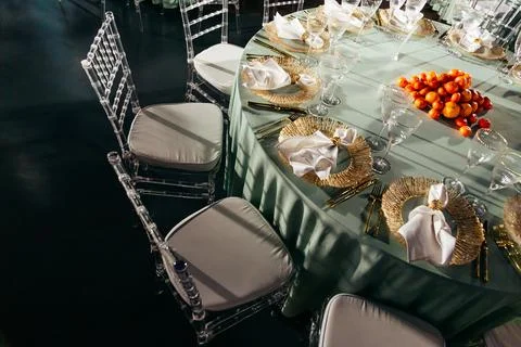 Top-down view of round table with tangerine centerpiece and Chiavari chairs Stock Photos