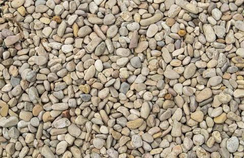 Top down view of rounded gravel and river pebbles in beige, tan, and grey t.. Stock-Fotos