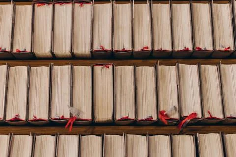 Top-down view of rows of old books with worn pages and red bookmarks Stock-Fotos