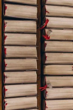 Top-down view of rows of old books with worn pages and red bookmarks Stock Photos