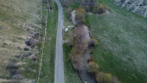 Top down view of rural asphalt road and flowing mountain river in Kazakhstan Видео 337467864
