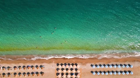Top-down view of sandy beach with sun umbrellas and turquoise sea water Stock Footage 301541124