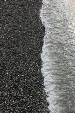 Top Down View of Sea Water at the Edge of a Pebble Beach Shore Stock Photos
