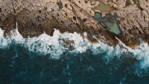 Top down view of sea waves foam on jagged coastline forming a natural edge Stock Footage 319872569